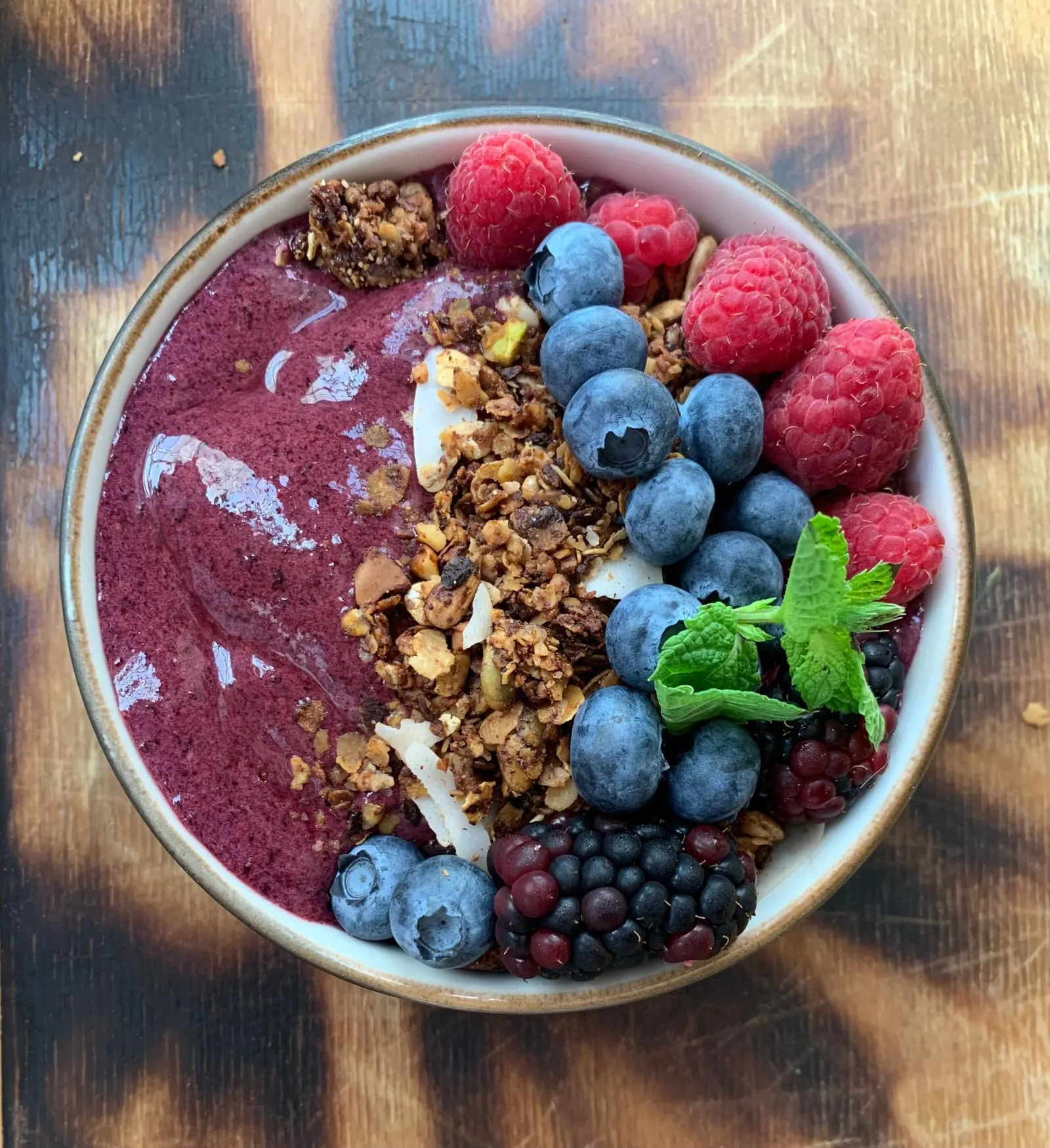 A bowl of açaí topped with granola and fresh fruit