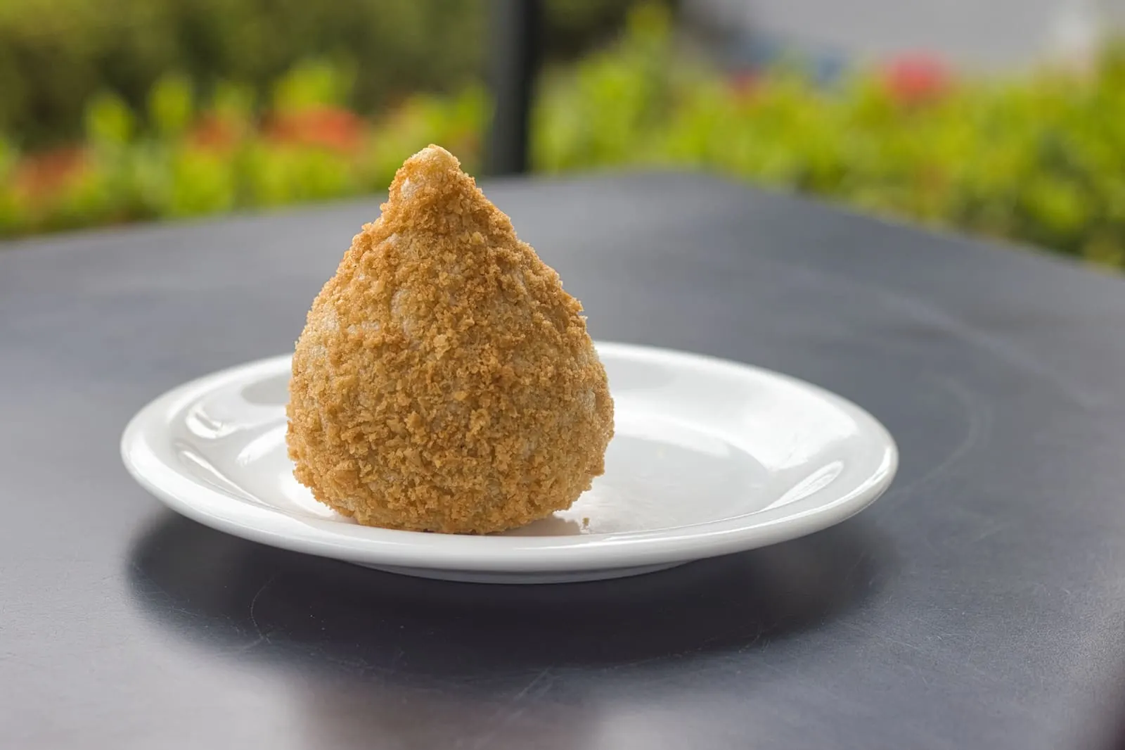 A golden fried coxinha, Brazil's teardrop-shaped chicken snack