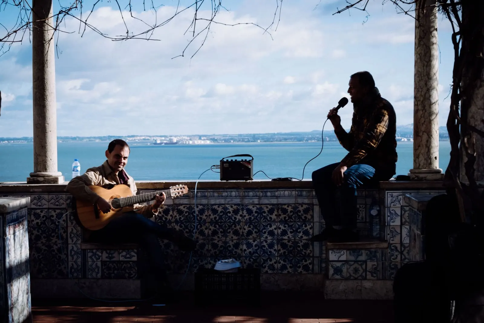 A fado guitarist and singer performing beside the Tagus river in Lisbon