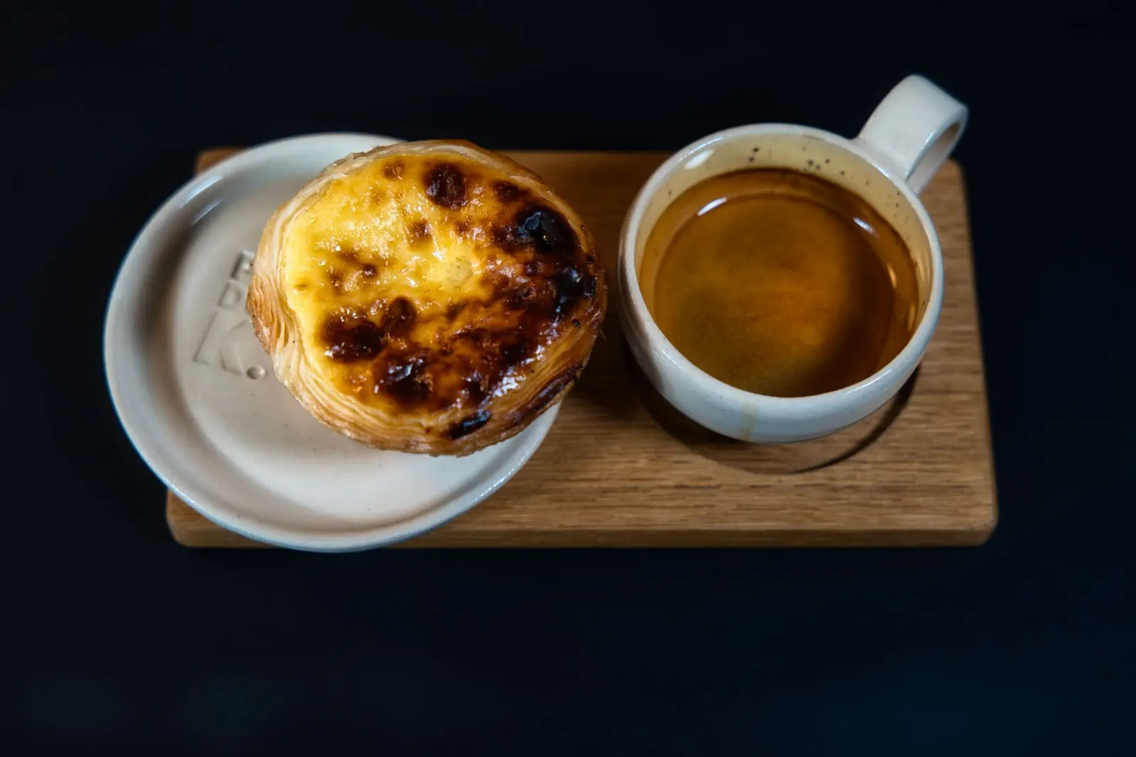 A pastel de nata custard tart served with a small espresso